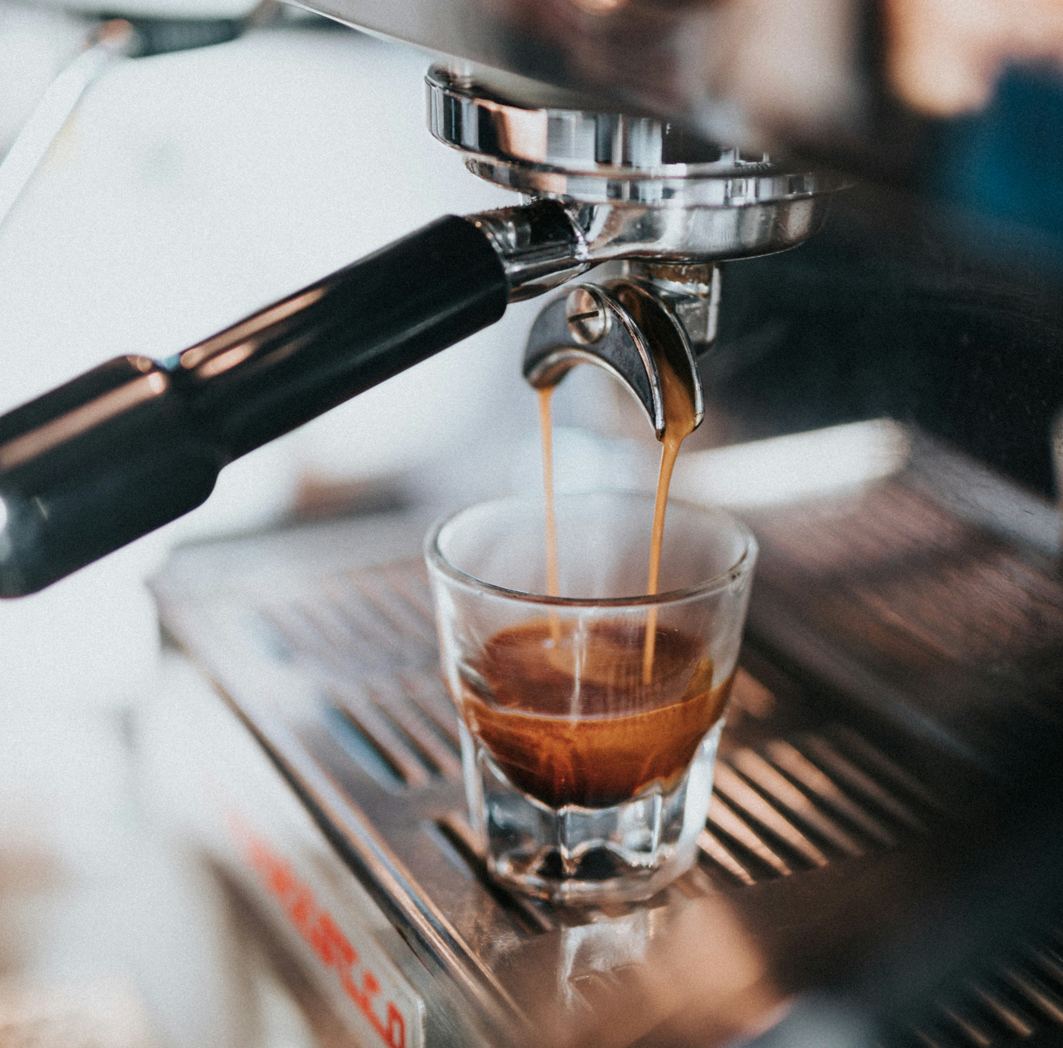 Espresso machine filling a glass cup